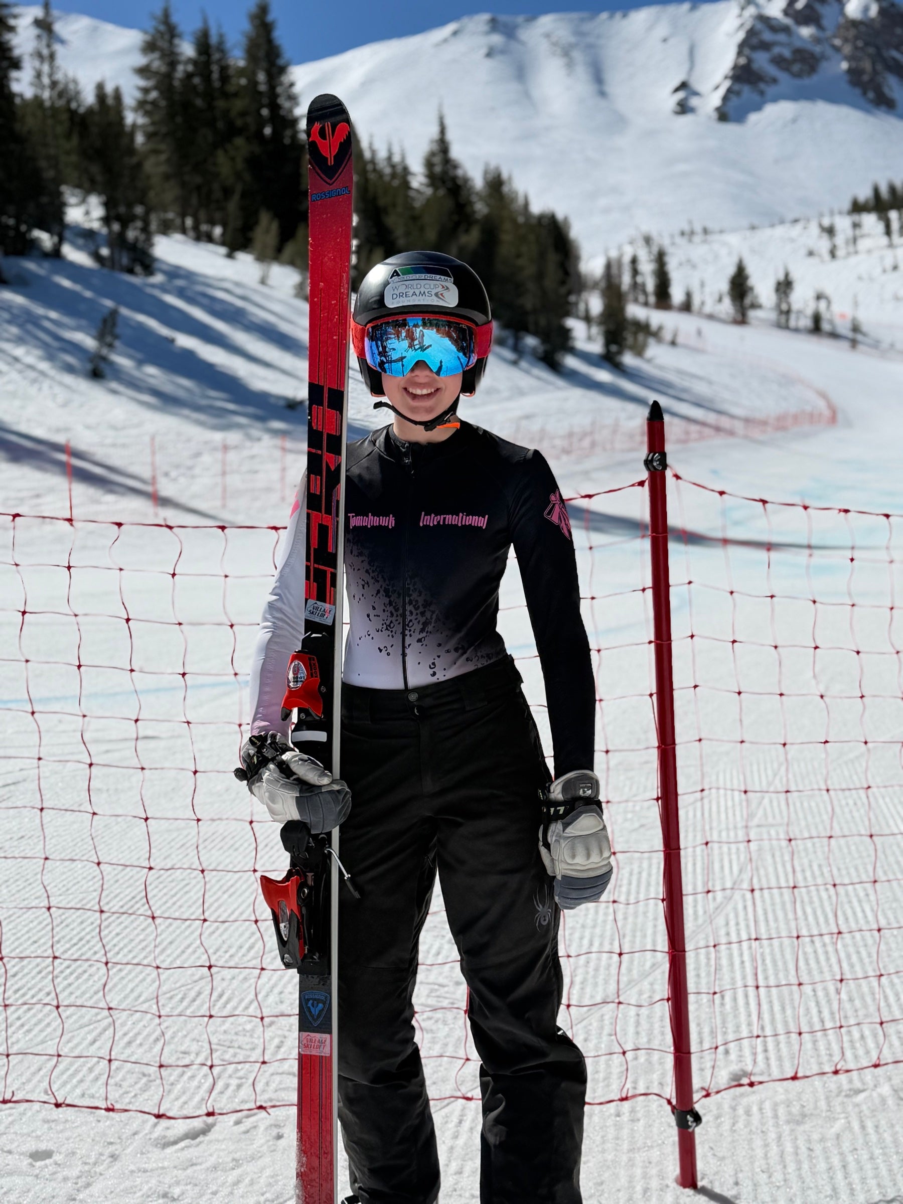 Ashlyn standing on the mountain in a Tomahawk race suit